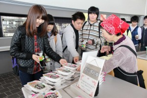 手作りのおにぎりと無菌パック米飯を手に笑顔を見せる学生